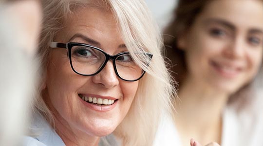 To kvinder smiler mod en tredje person.