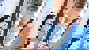 Patient og læge står og smiler til hinanden.