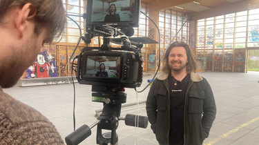 Psykolog Jonathan Smed fra Aleris foran kameraet i optagelse af film om trivsel