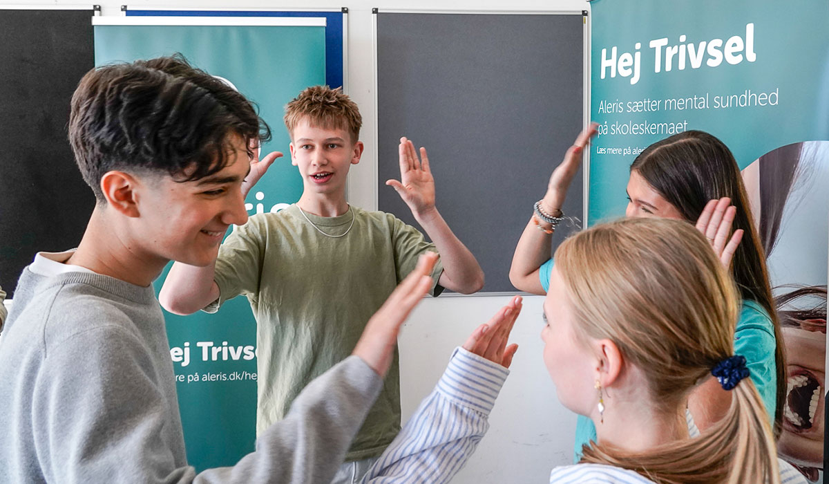 Billede af elever fra 8. klasse, der giver hinanden high five, mens de spiller Trivselsspillet.