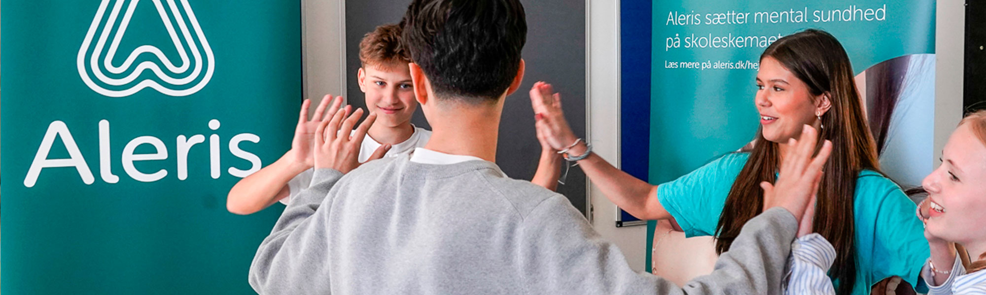 Billede af elever fra 8. klasse, der giver hinanden high five, mens de spiller Trivselsspillet.