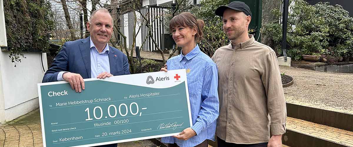 Vinder af årets førstehjælper 2024 får overrakt en check på 10.000 kr. af Røde Kors' Generalsekretær.