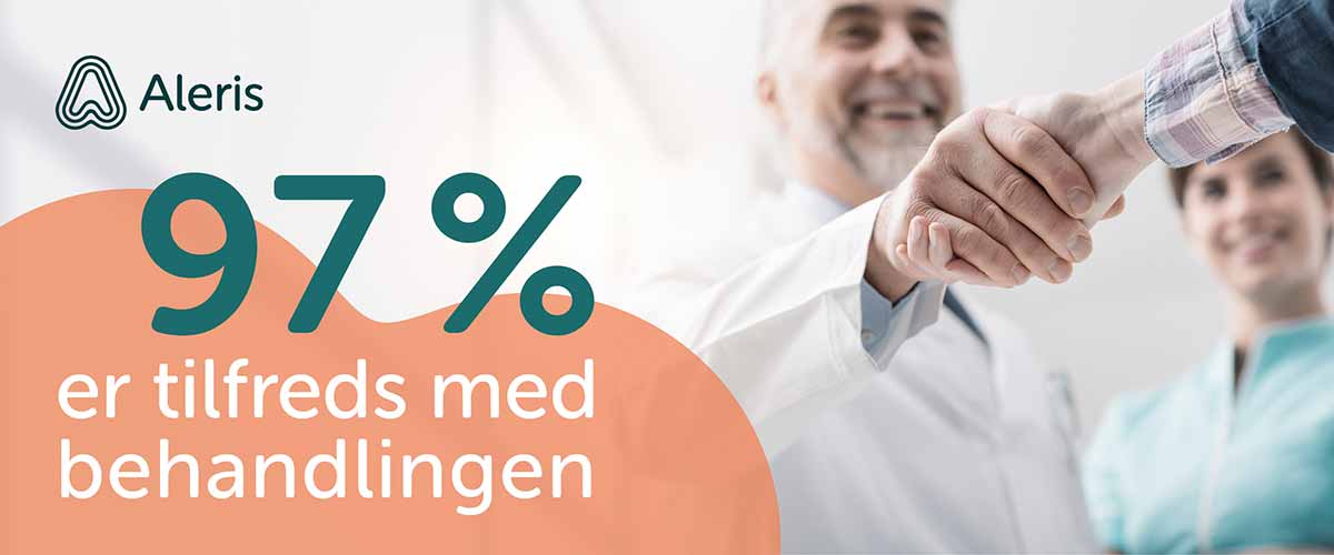 Læge giver smilende hånd til en patient.