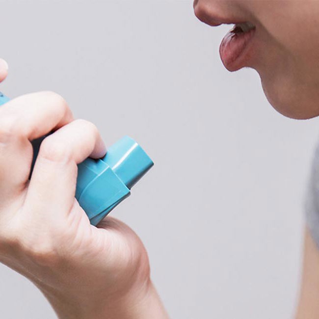 Læge rådgiver patient i, hvordan man bruger inhalator.