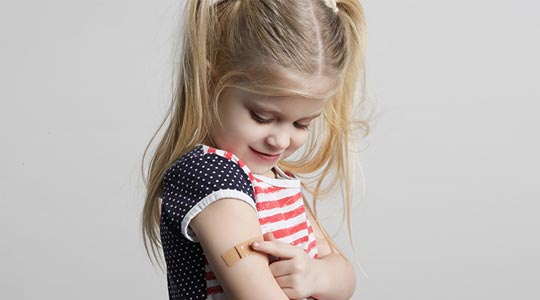 Et barn sidder hos en af Aleris børnelæger, der tjekker barnets heldbred og udvikling.