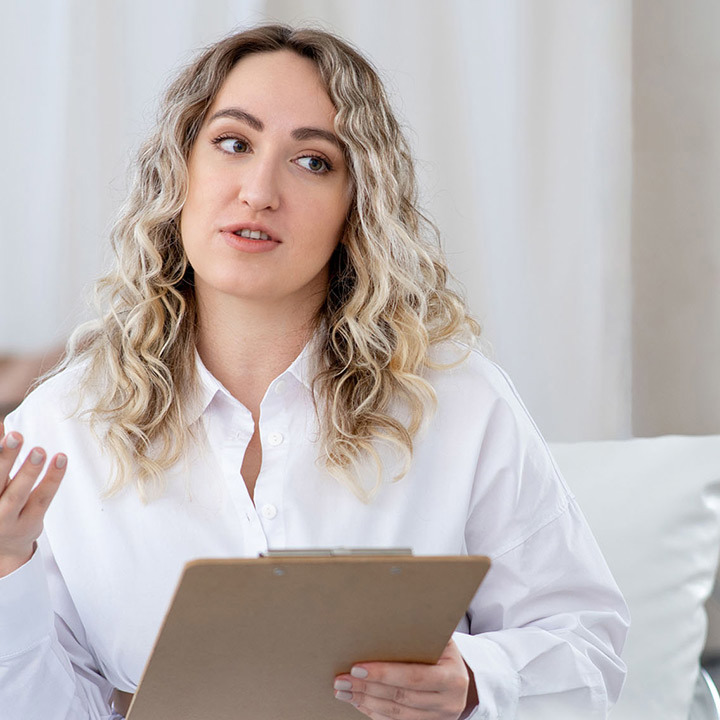 En kvindelig diætist sidder og taler med en klient.