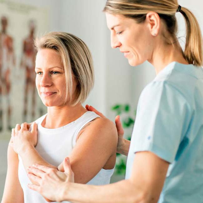 Fysioterapeut laver øvelser med patient.