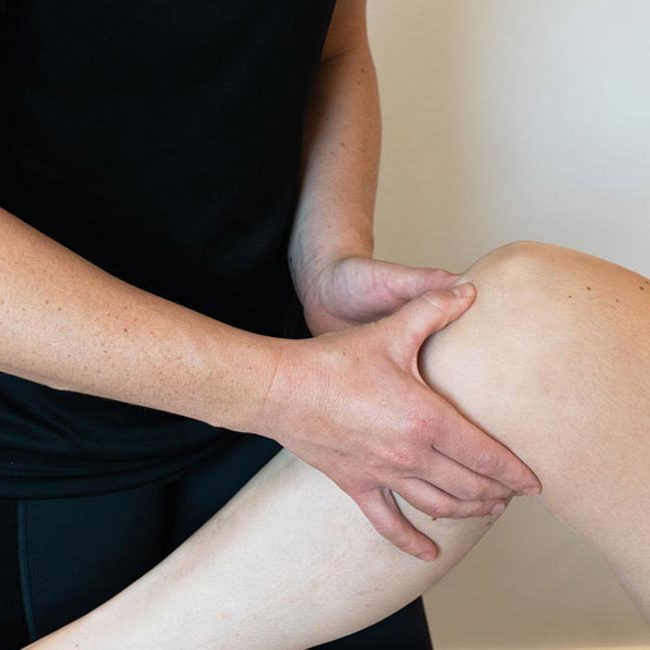 Fysioterapeut fra Aleris laver øvelser med patients knæ.