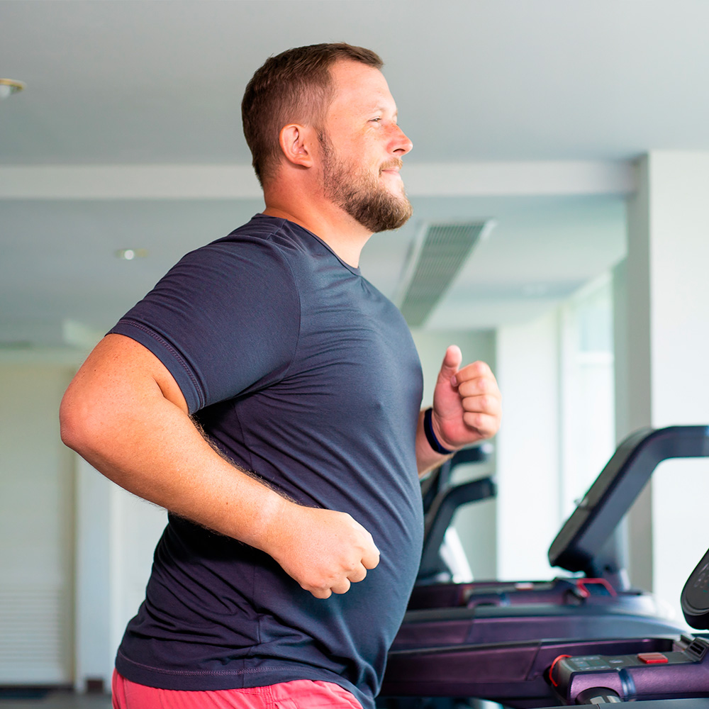 Mand på løber på løbebånd i træningsmiljø