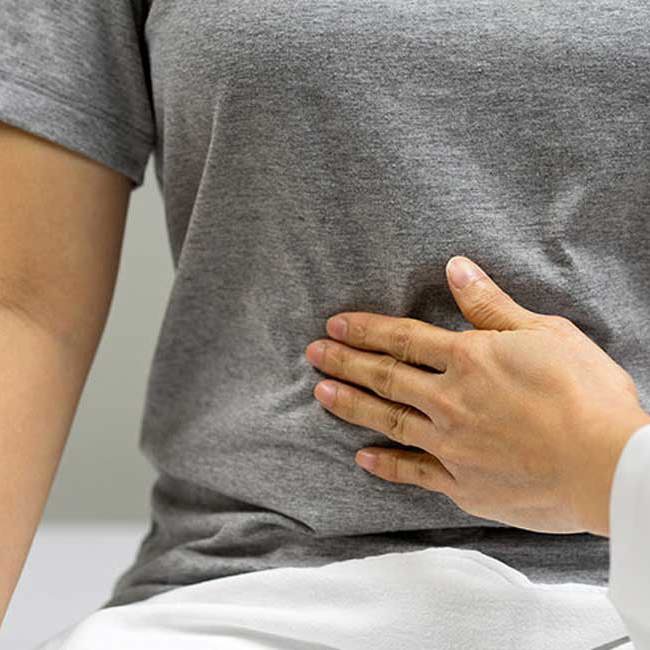 Læge mærker kvinde på maven.