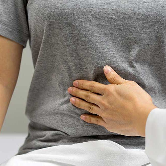 Læge mærker kvinde på maven.