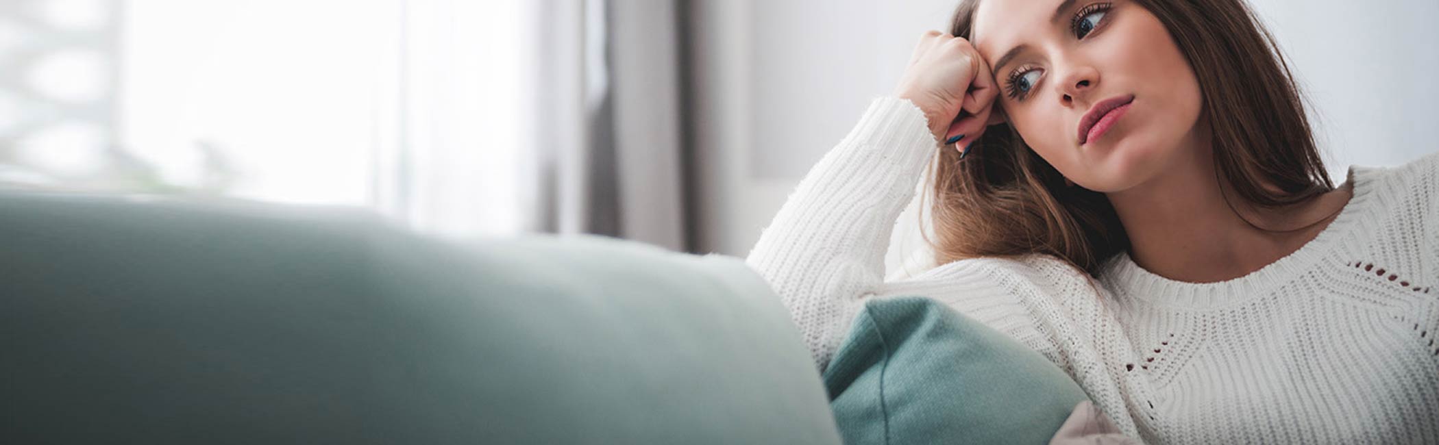 Kvinde sidder tænkende og kigger.