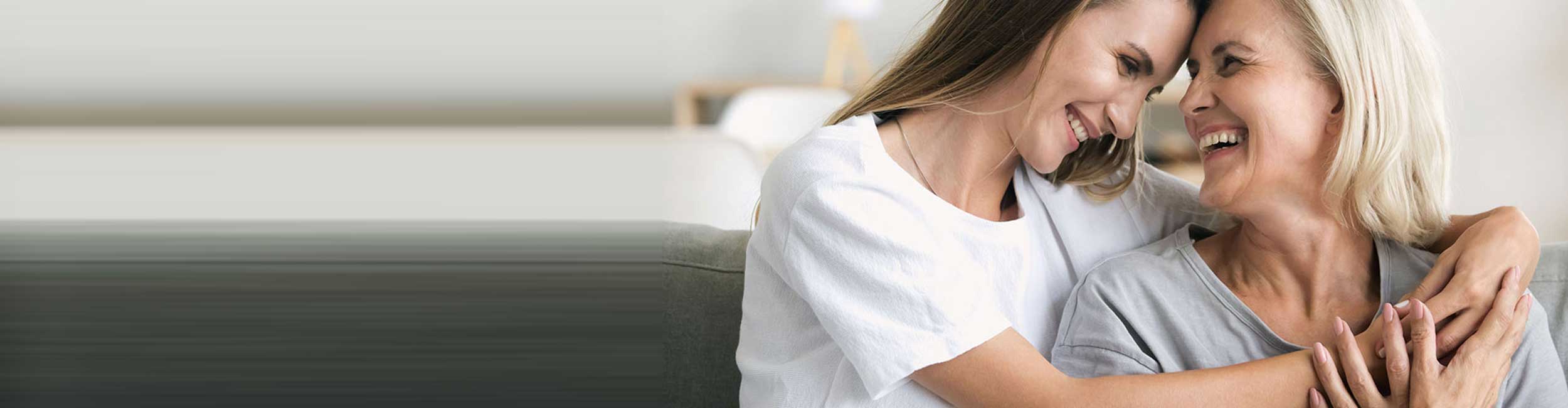 Mor og datter holder tæt om hinanden og smiler.