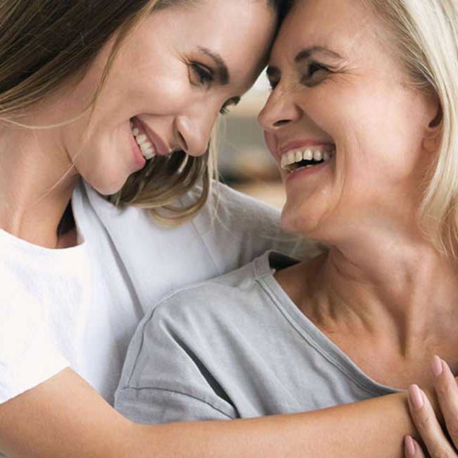 Mor og datter holder tæt om hinanden og smiler.