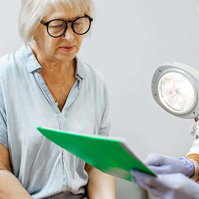 Patient og ældre kvinde sidder under en konsultation.