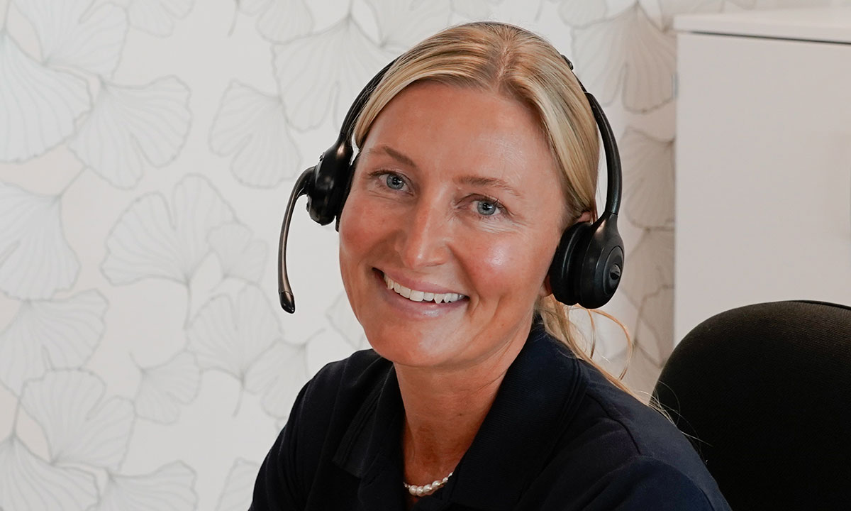 Helbredssygeplejerske i Aleris Health sidder og taler i telefon.