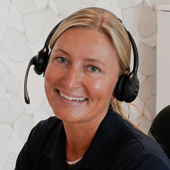 Helbredssygeplejerske i Aleris Health sidder og taler i telefon.