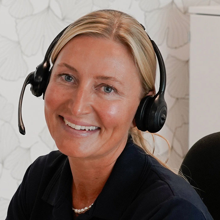 Helbredssygeplejerske i Aleris Health sidder og taler i telefon.