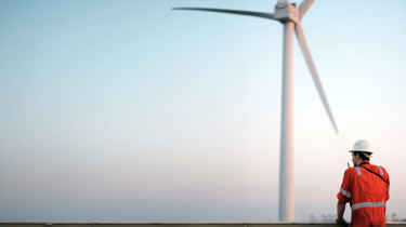 Mand står og kigger ud på vindmøller.