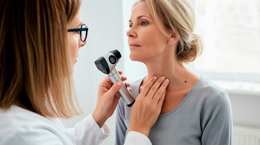 Hudlæge screener for modermærkekræft på halsen af en kvinde.