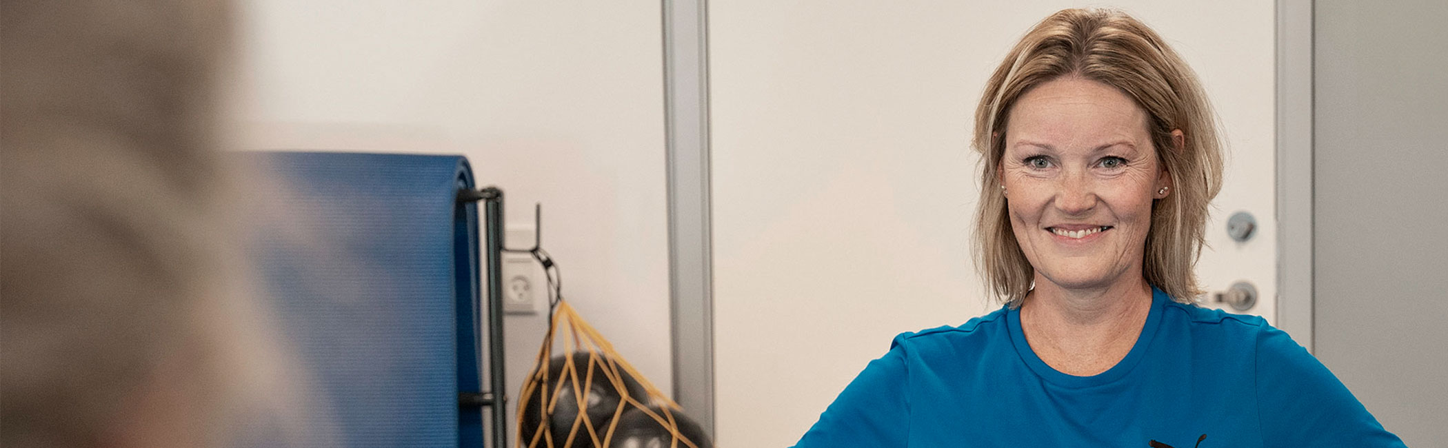 Kvinde er til træning hos Aleris Fysioterapi.