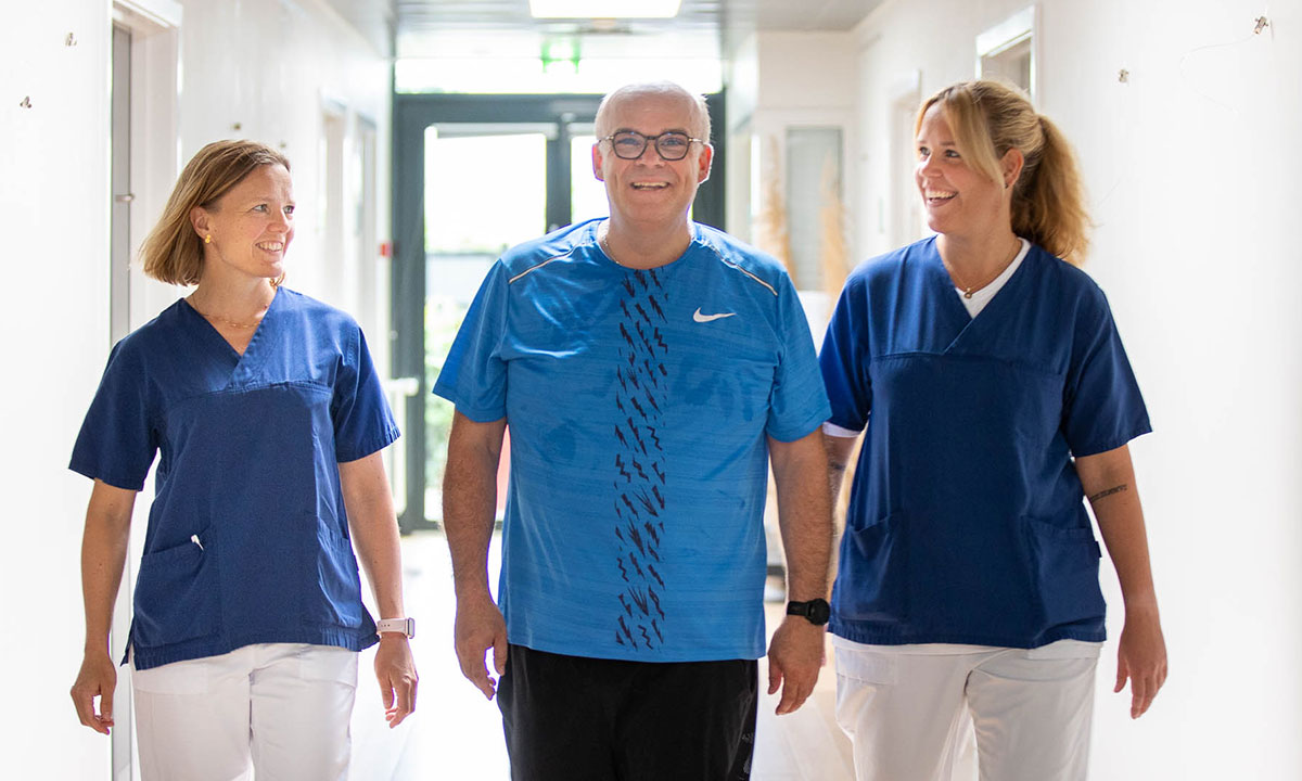 Patient og læger går smilende på et af Aleris hospitaler.