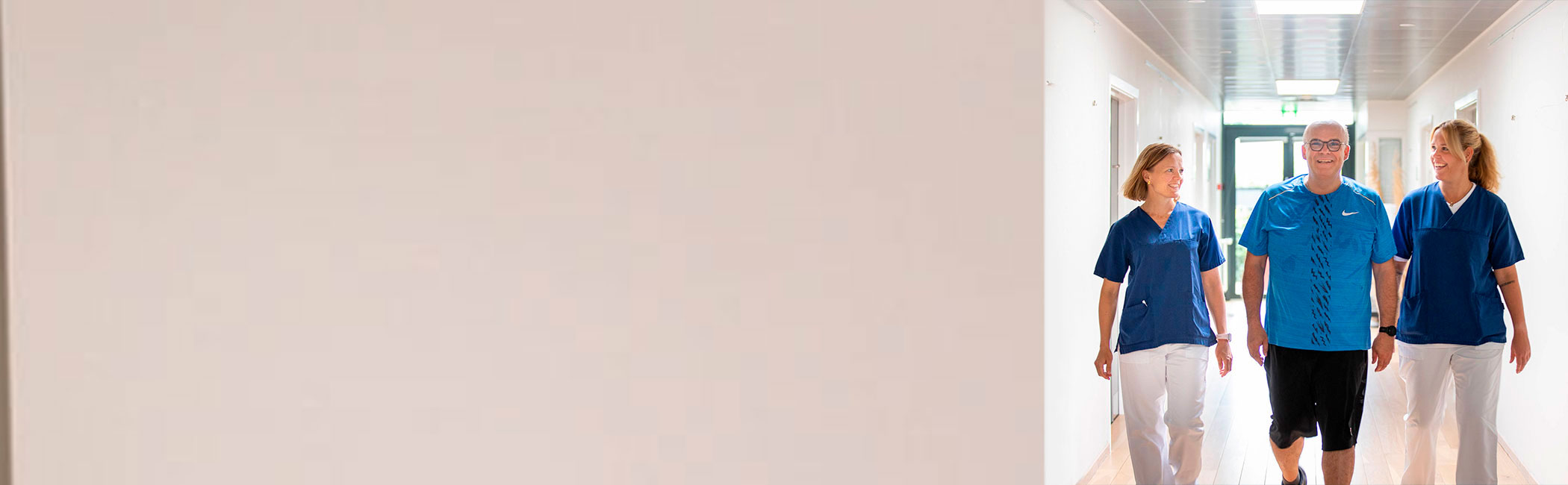 Patient og læger går smilende på et af Aleris hospitaler.