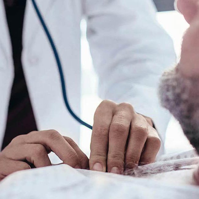 Læge og patient smiler til hinanden.