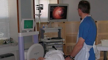 Læge kigger på scanning af patient som undersøges for mave-tarm sygdomme.