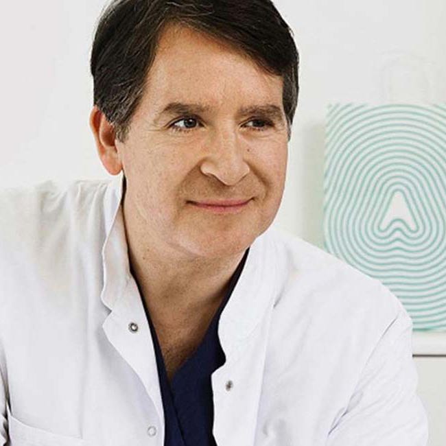 Mandlige neurolog sidder og snakker med en patient.