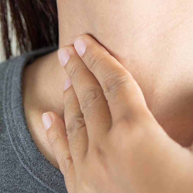 En kvinde har ondt i sine mandler i halsen.