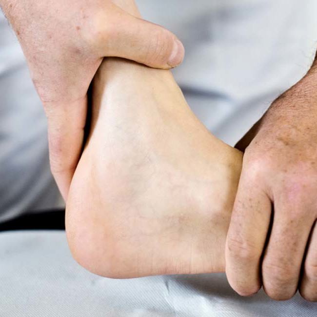 Ortopædkirurg mærker patients ankel.