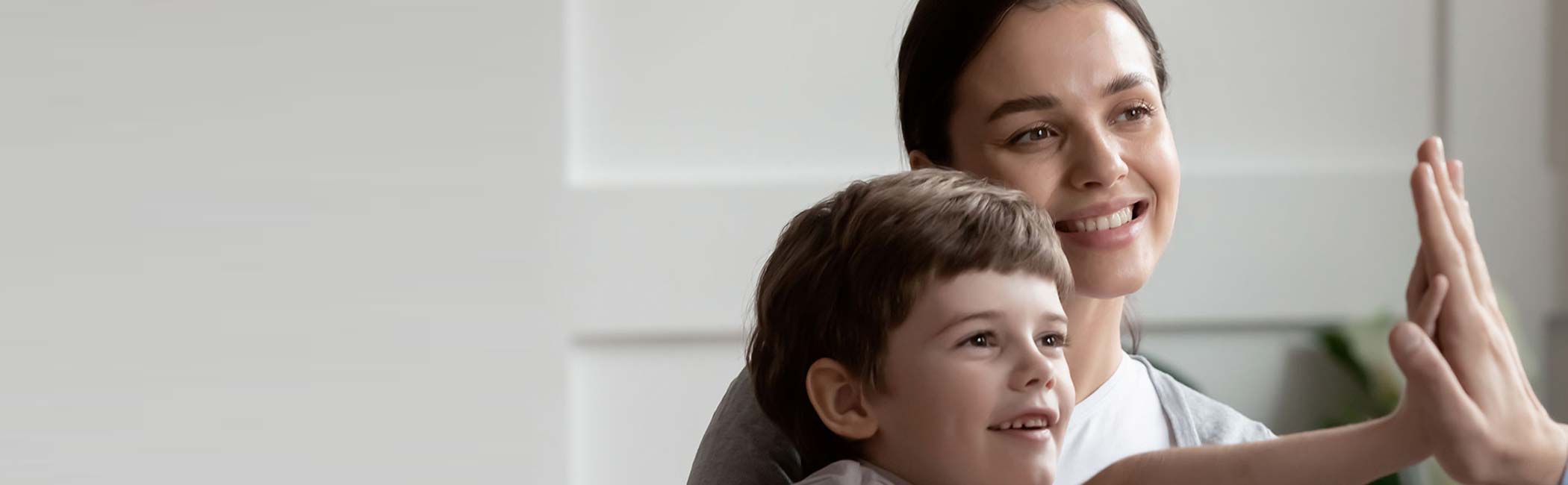 En mor og et barn smiler ved et besøg hos en børneortopædkirurg.