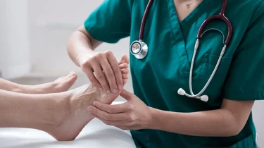 Læge undersøger storetåen for slidgigt.