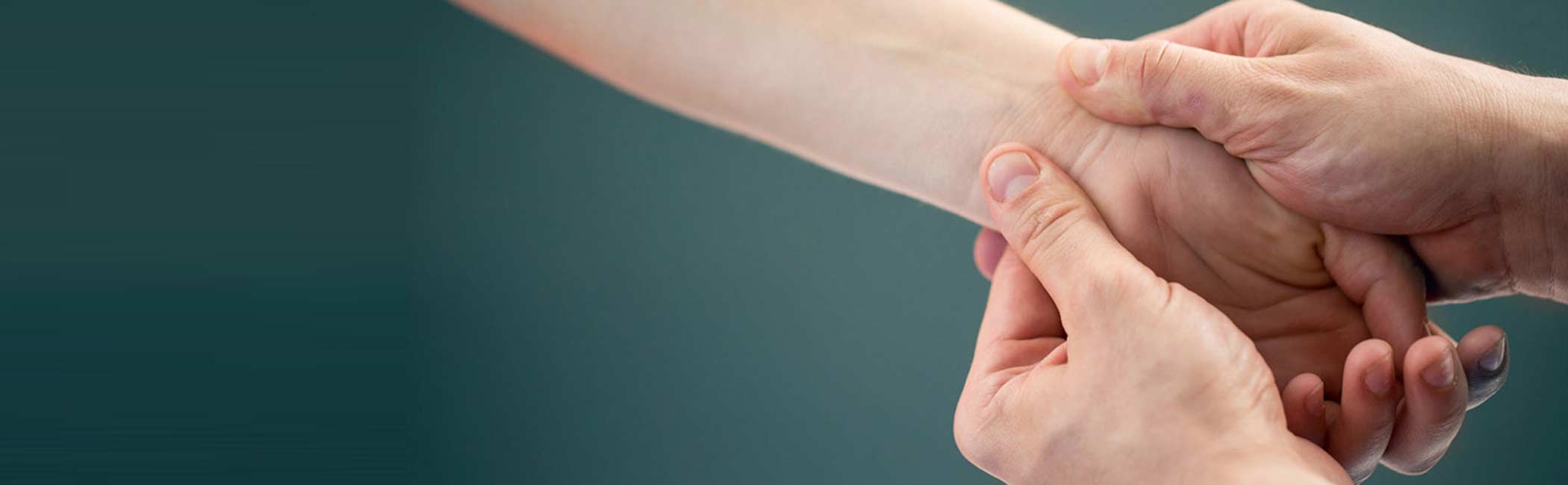 En kvinde masseres i hånden.