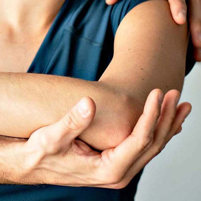 Ortopædkirurg mærker patient om albuen.