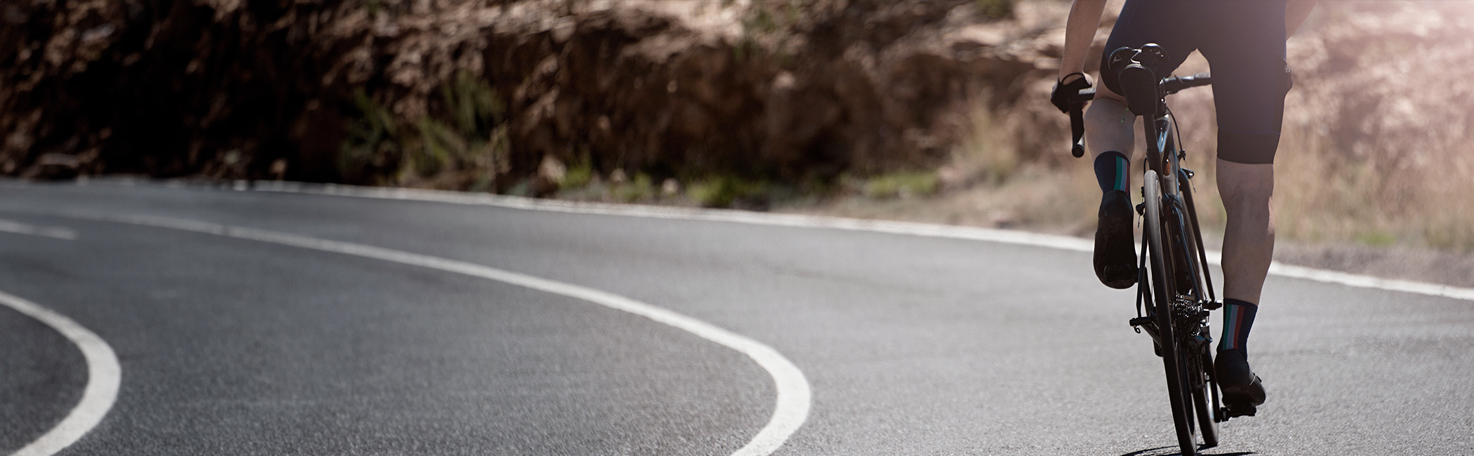 Cykelrytter træder hårdt i pedalerne på vej op ad en bakke