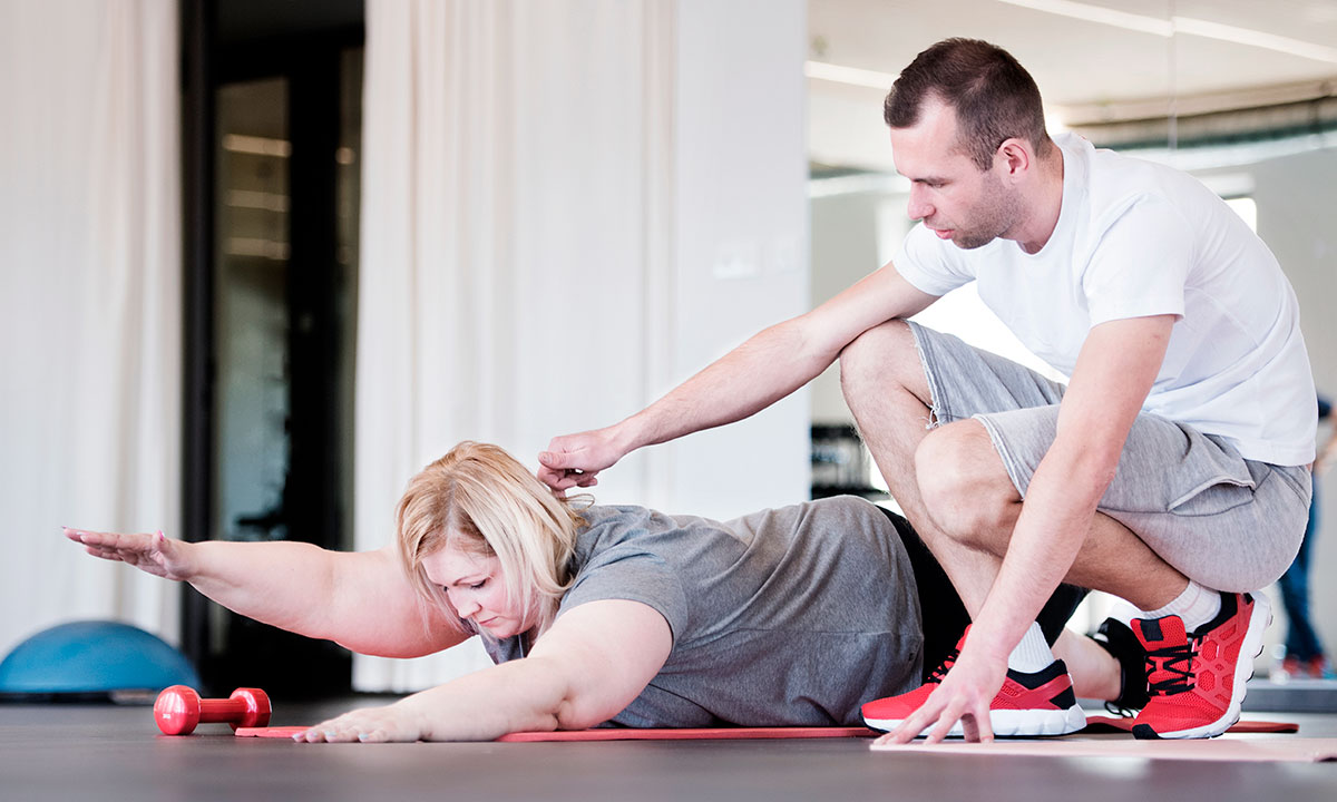 Fysioterapeut i Aleris vejleder overvægtspatient i optimal træning.