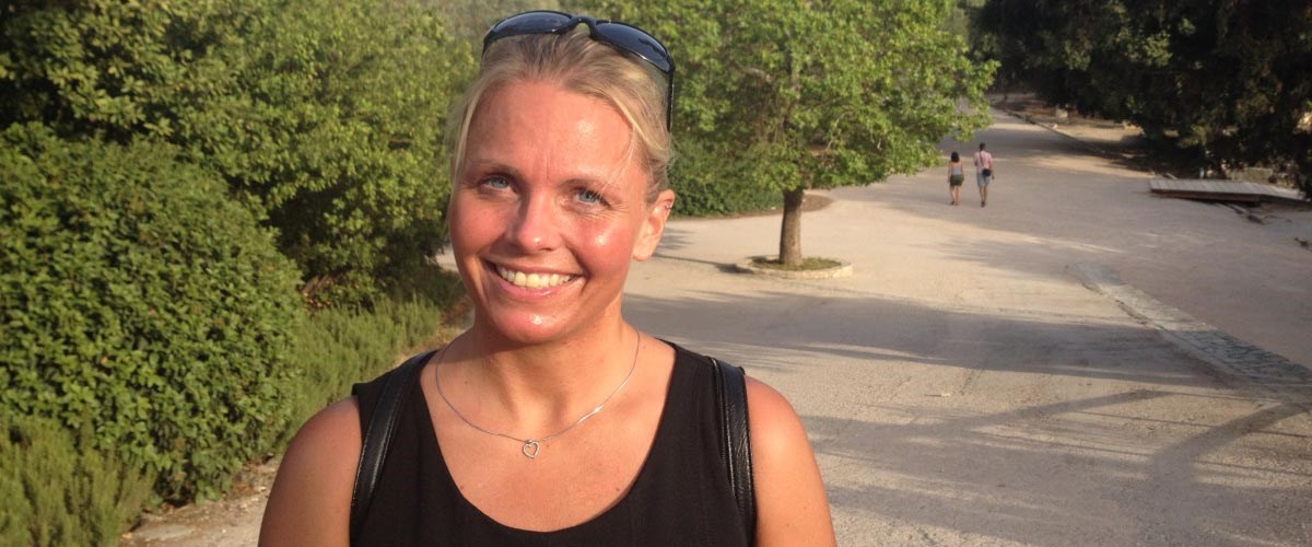 Glad kvinde smiler til kameraet over sit store vægttab efter en overvægtsoperation.