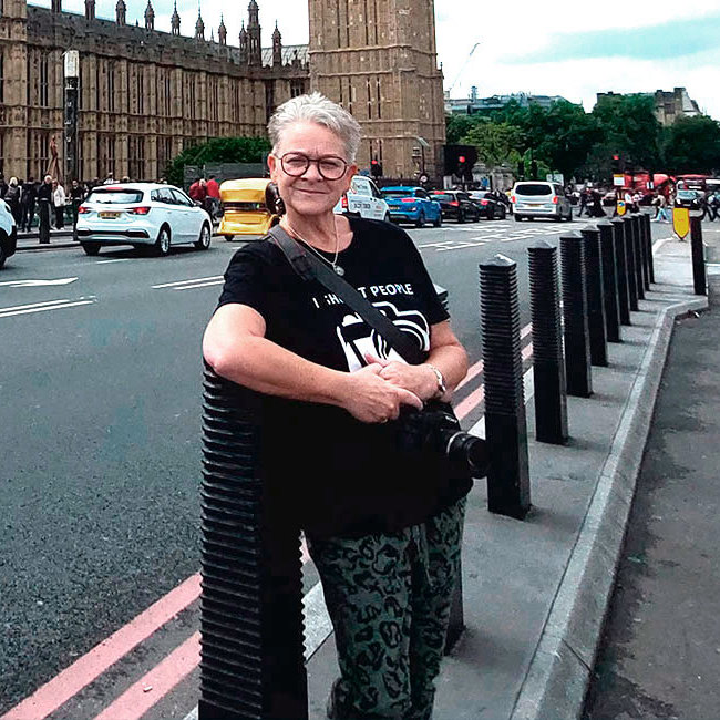 Kvinde står på gaden og smiler.