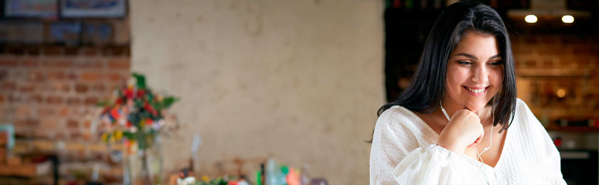 En medarbejder i Aleris kundeservice sidder og taler med en patient i telefon med headset på.