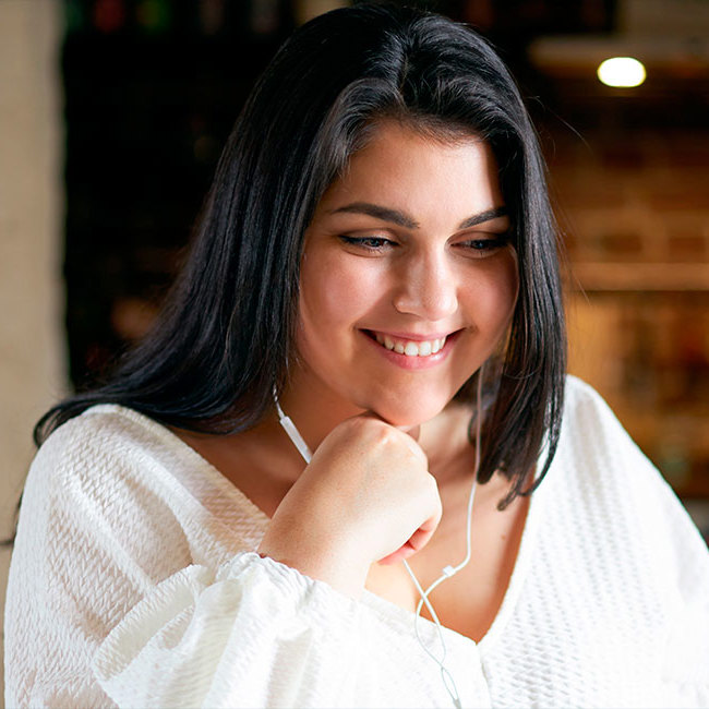 En medarbejder i Aleris kundeservice sidder og taler med en patient i telefon med headset på.