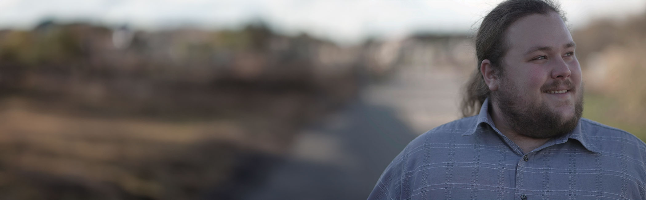 Overvægtig mand går og smiler.