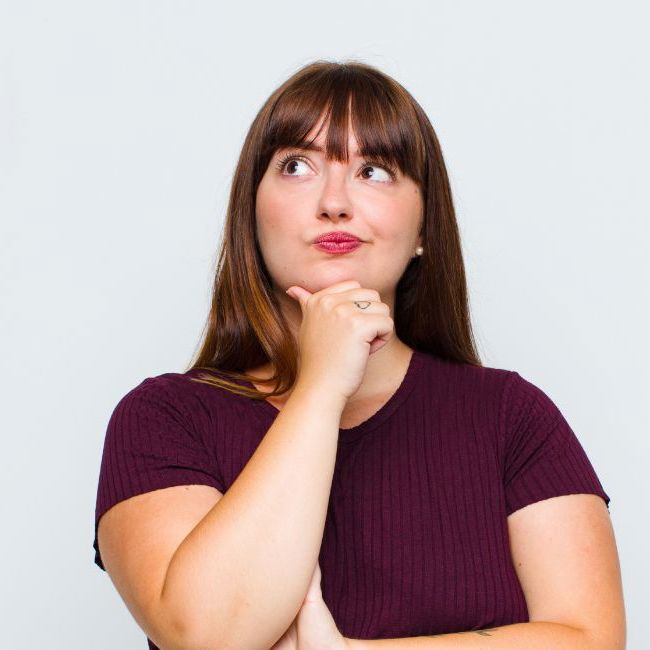 Overvægtig kvinde står og tænker.