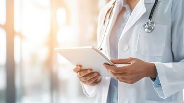 En læge står med en patientplan på et af Aleris hospitaler.