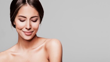 En kvinde kigger smilende ned på jorden.