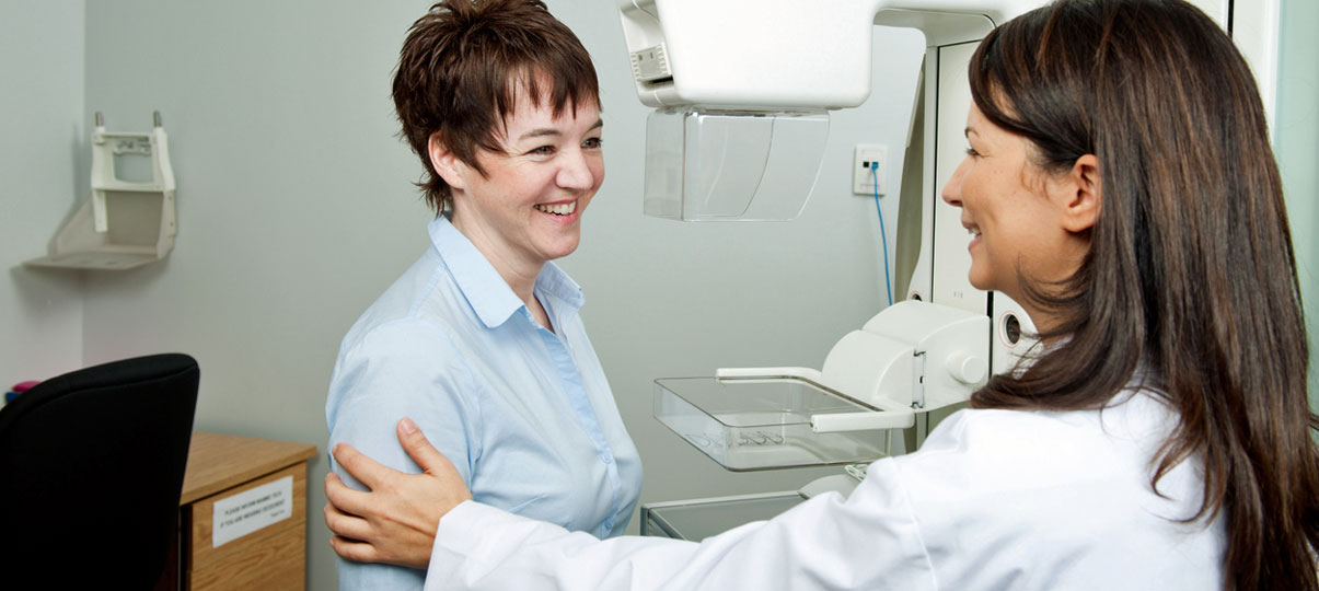 Smilende læge og patient fører en samtale.