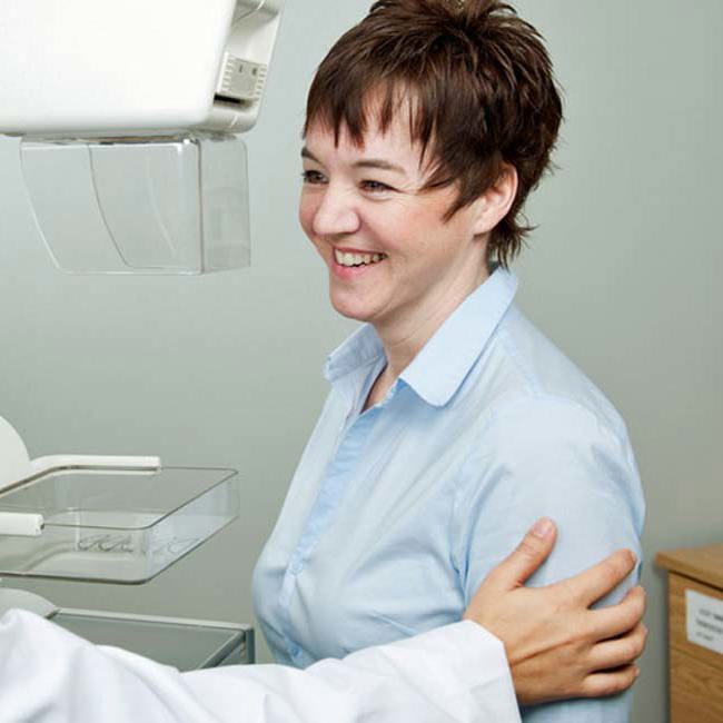 Smilende læge og patient fører en samtale.