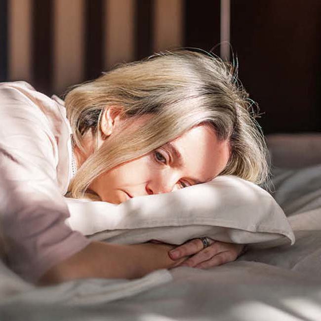 Kvinde 40+ ligger på maven i sengen og kan ikke sove.
