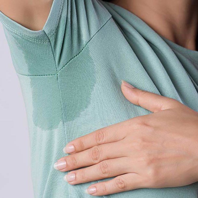 En kvinde har svedt igennem sit tøj.